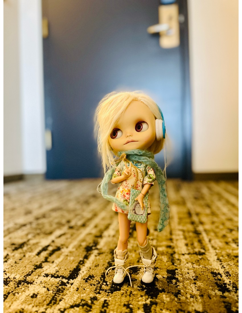 Blythe in hotel hallway with headphones